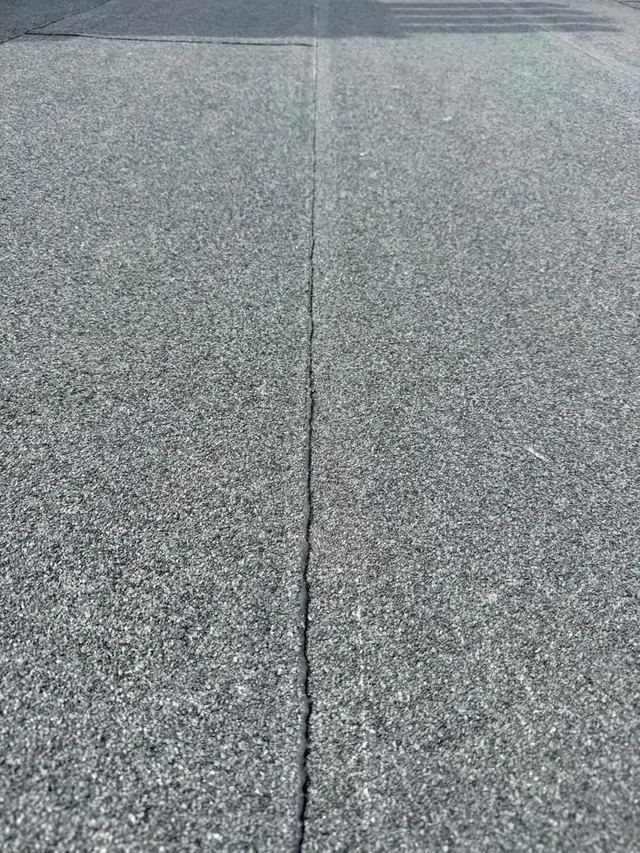 Overlapping van dakbanen — Detail van de overlap tussen twee bitumineuze dakbanen.